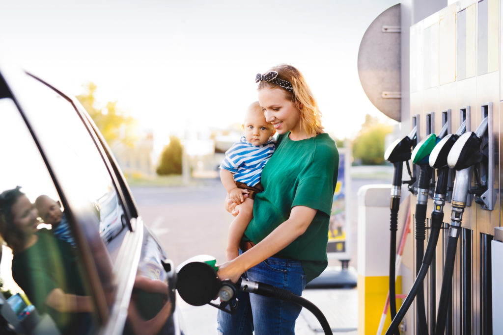 Mom Fueling Up At Pump While Holding Baby